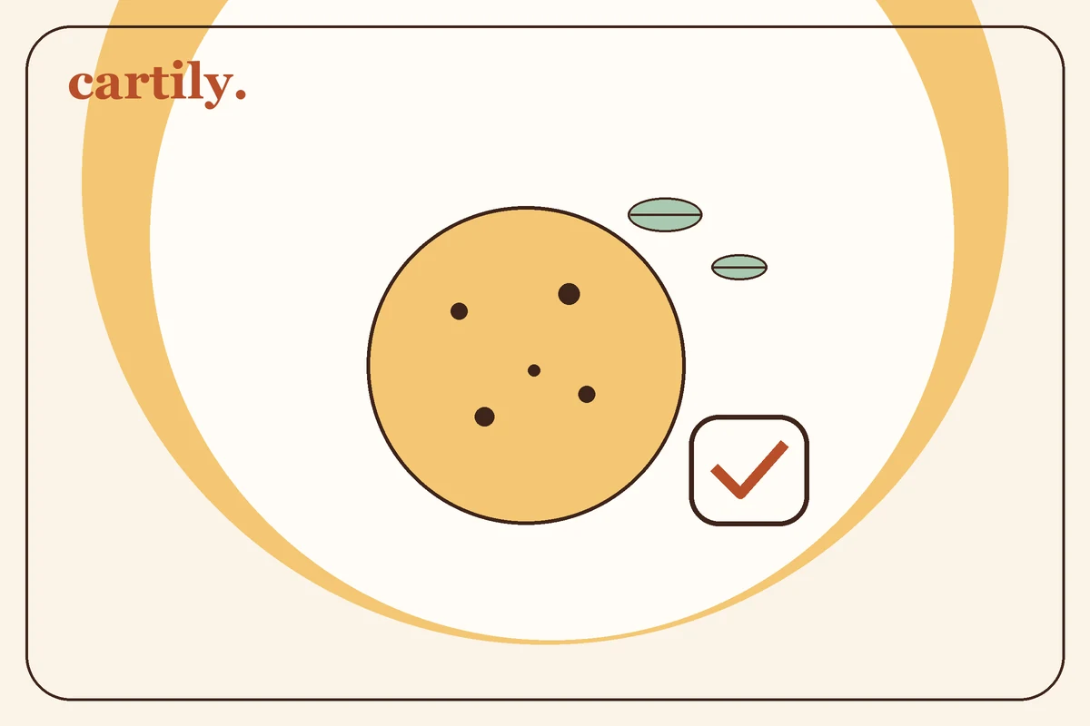 Illustration of a cookie with leaves and a checkmark.